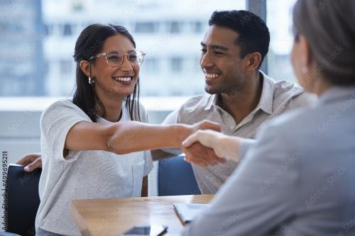 Woman shakes hand with person after she and husband sign on with United Healthcare insurance coverage