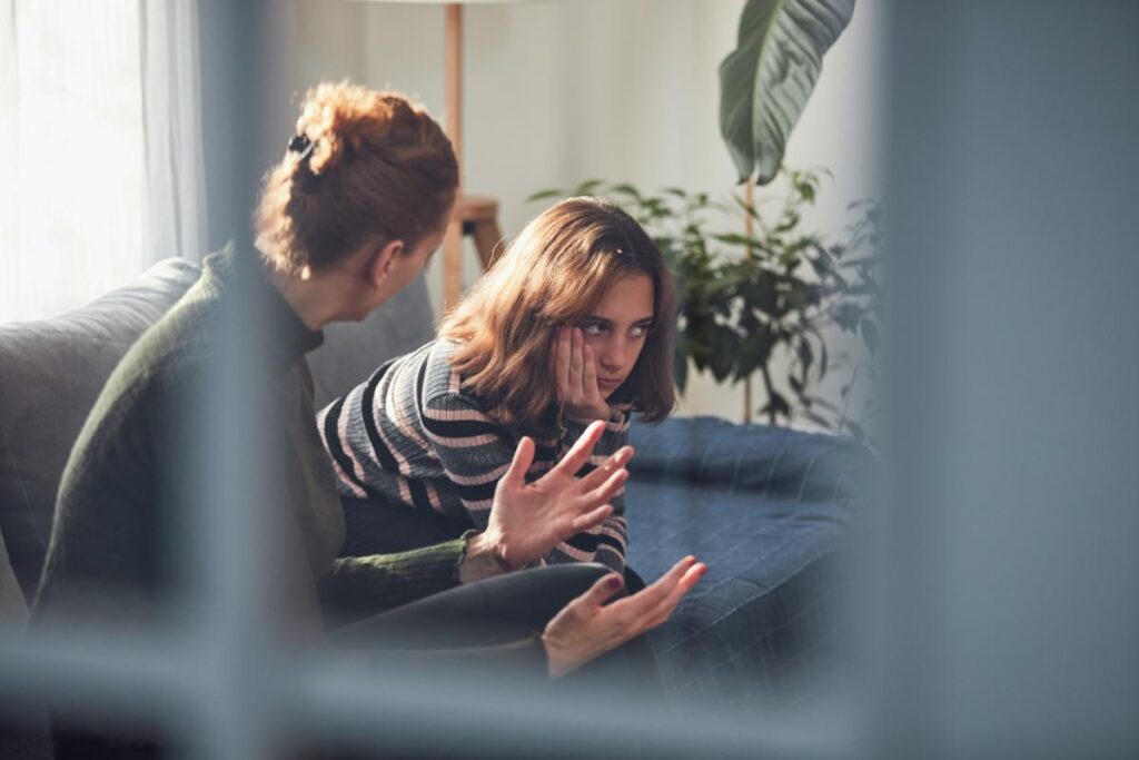Parent talks to teen on couch about how to control impulsive behavior