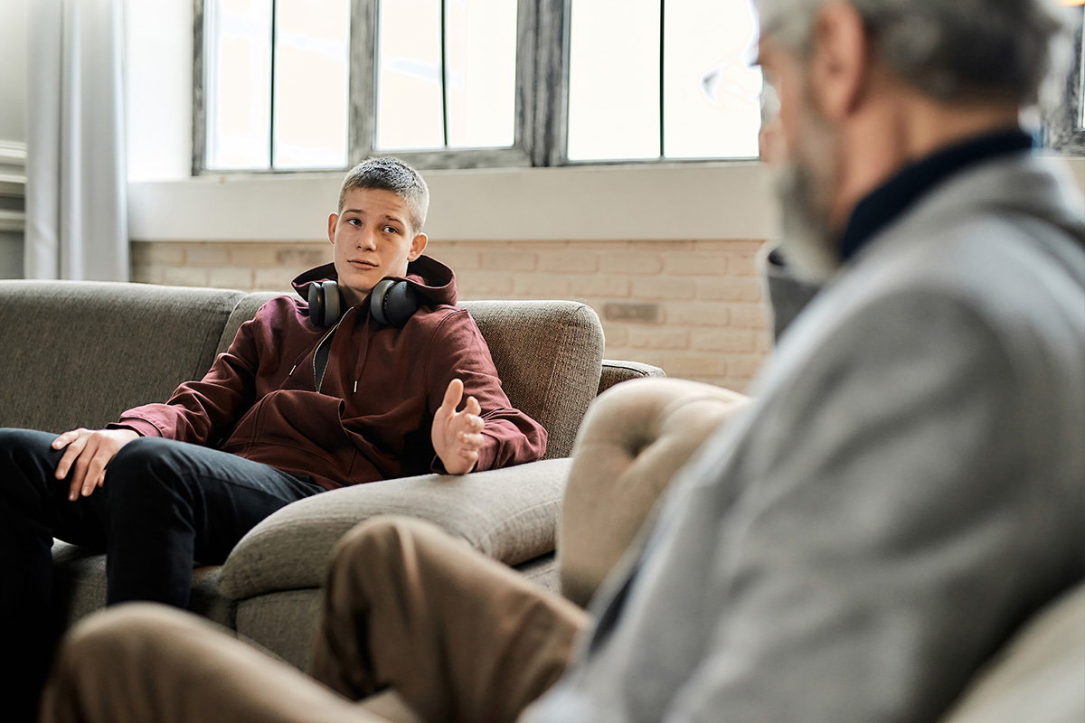 Therapist talks to teen boy during teen therapy session